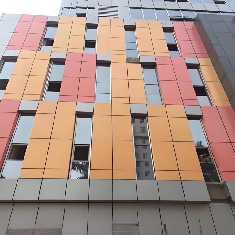 Orange and red facade wall panels arranged around window openings