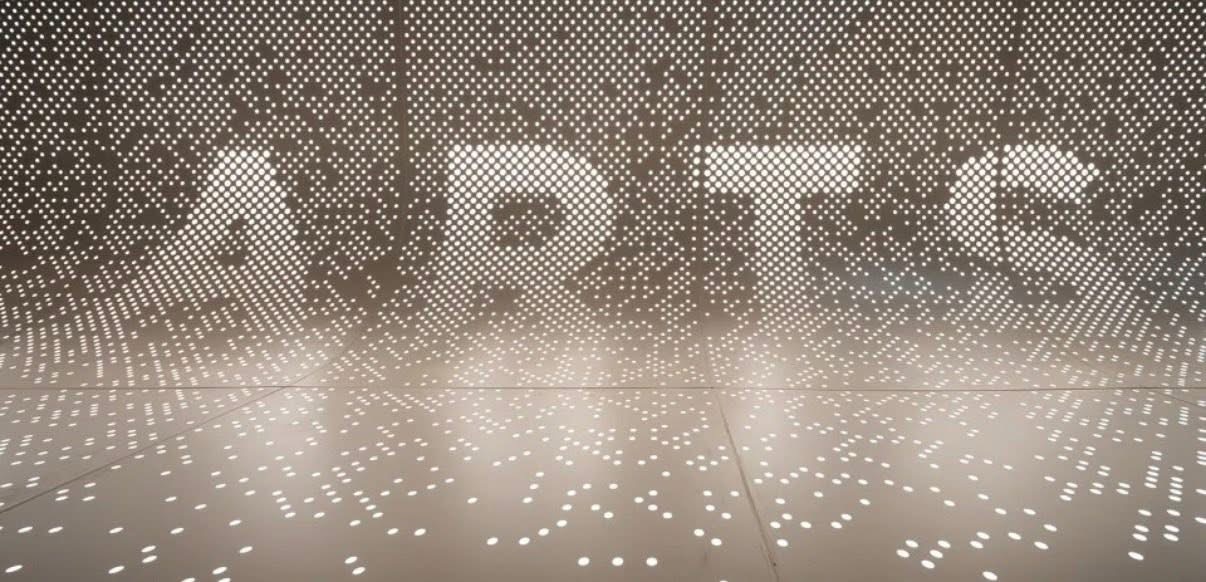 Close up of perforated aluminum panel with backlit dot pattern and shadow effect