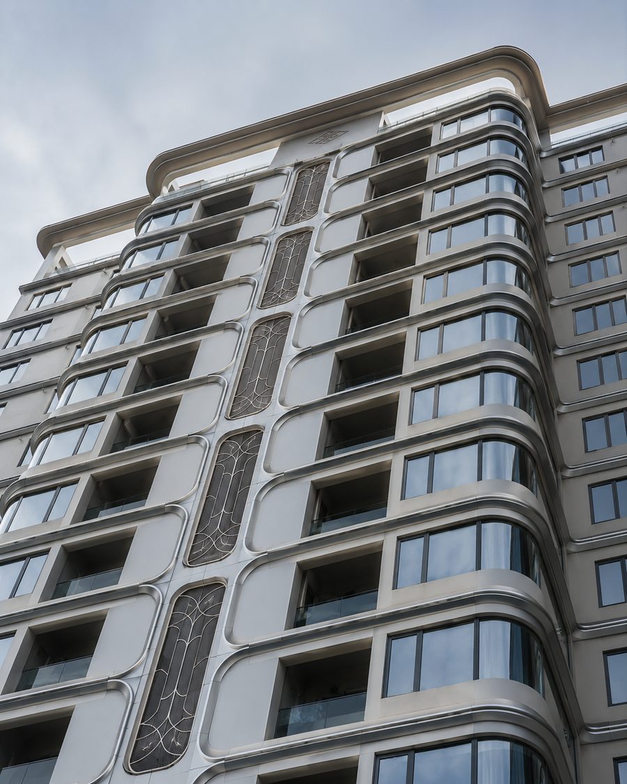 Double curved solid aluminum panel facade detail around glass curtain wall by Punchuk