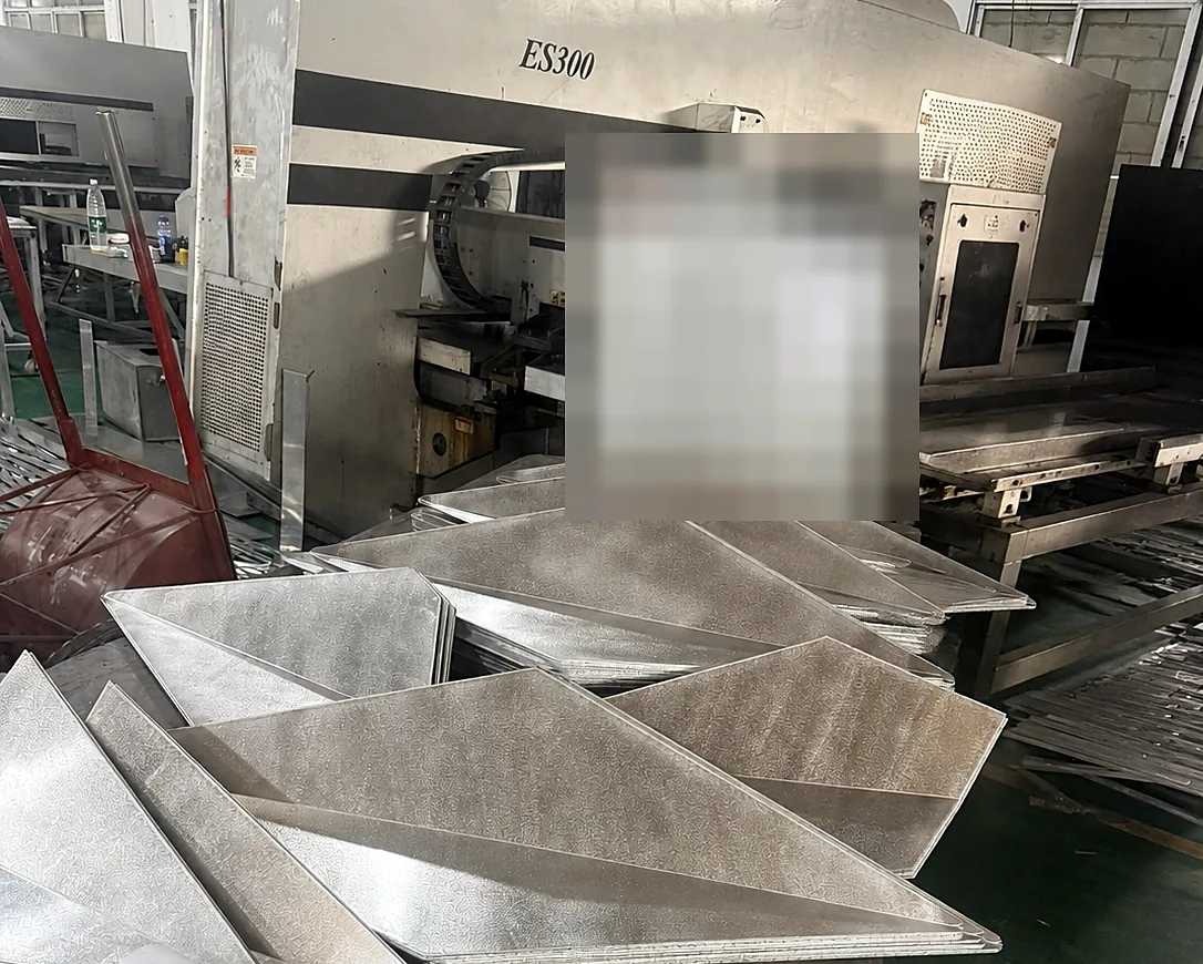 Batch of unfinished folded solid aluminum components staged beside workshop equipment during production for the Guangzhou project.