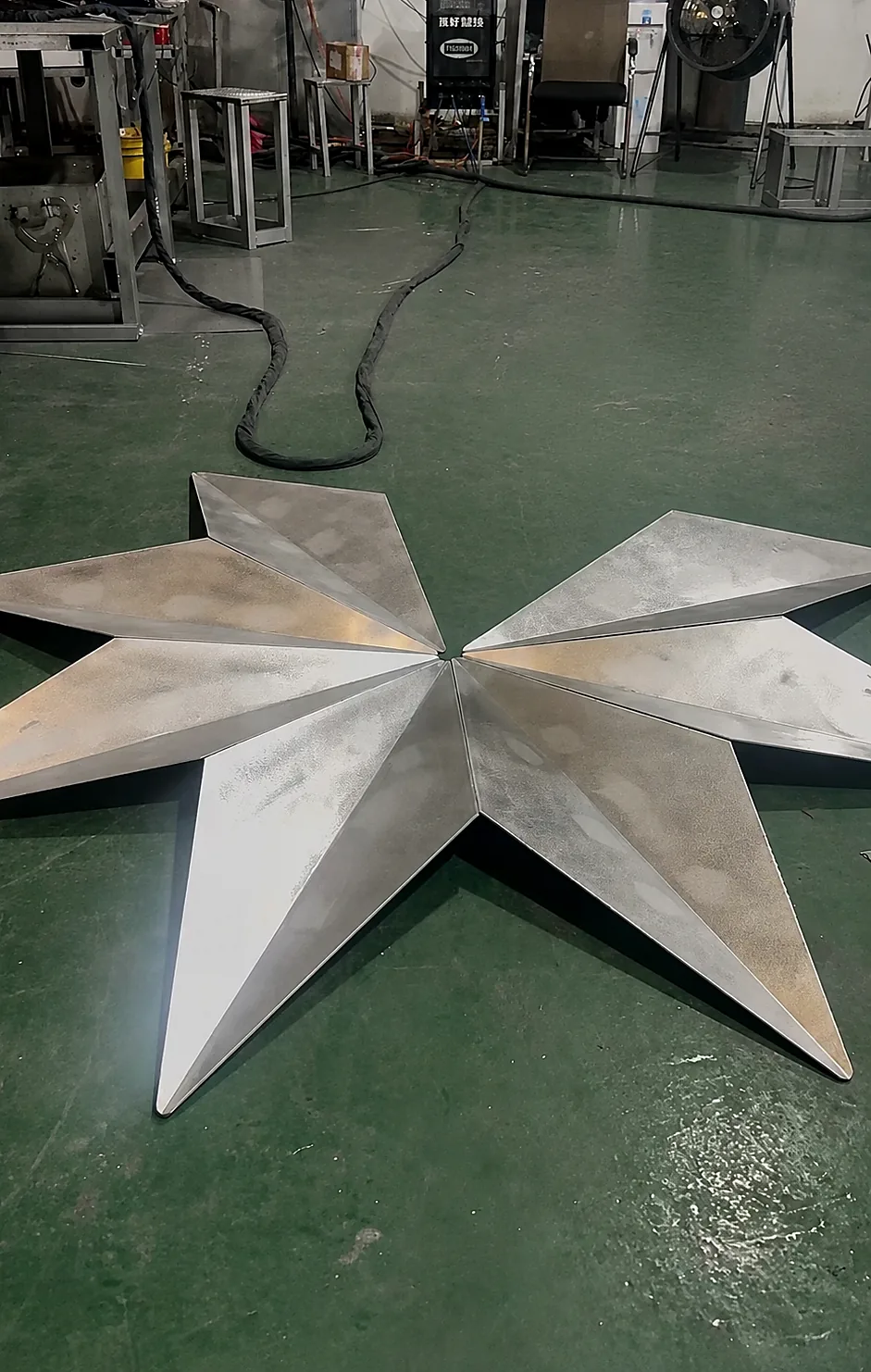 Unfinished folded solid aluminum modules arranged in a radial tree pattern on the Punchuk workshop floor for fit-up review.