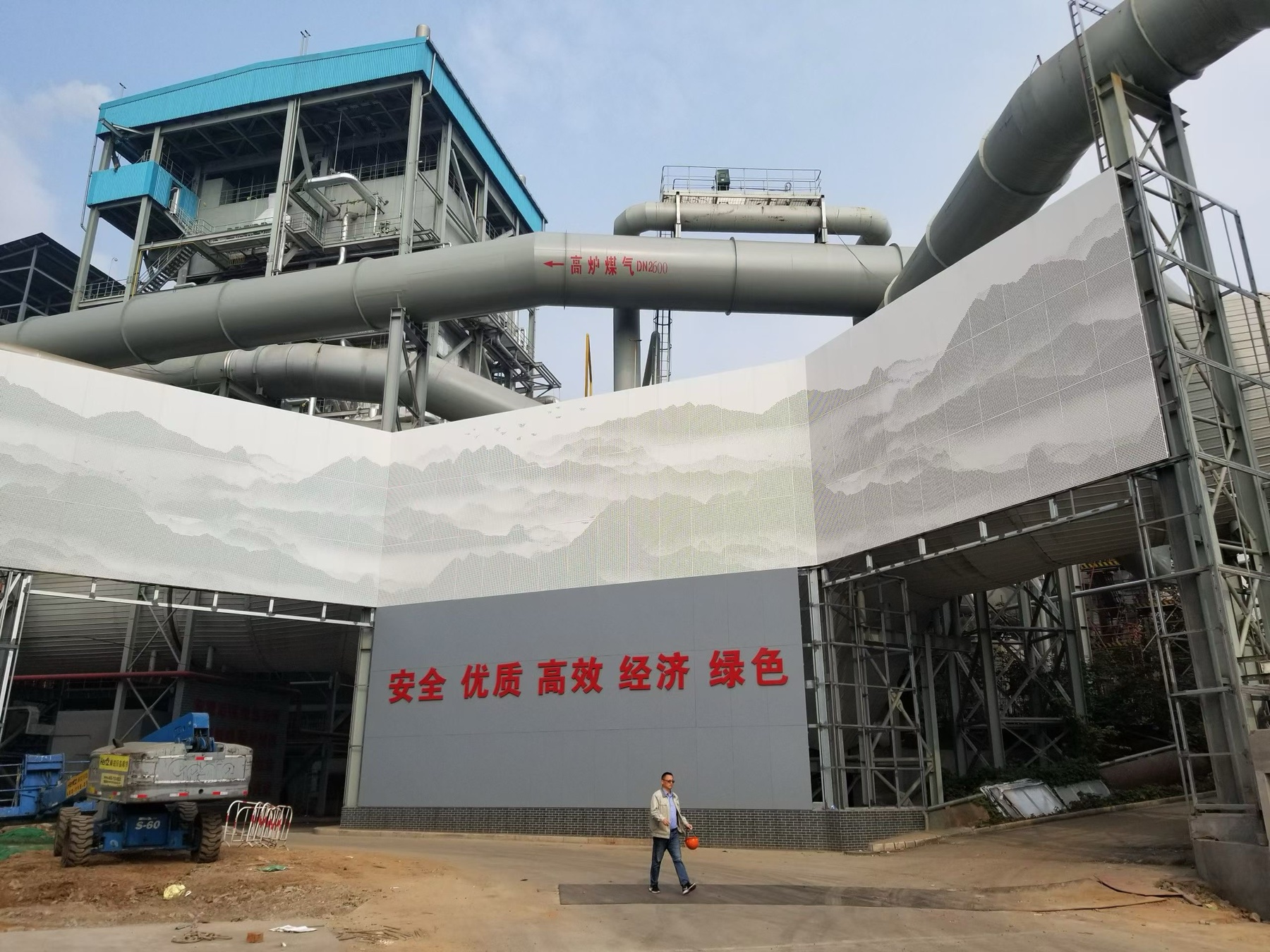 Industrial project facade screen using perforated aluminum panels with mountain landscape artwork