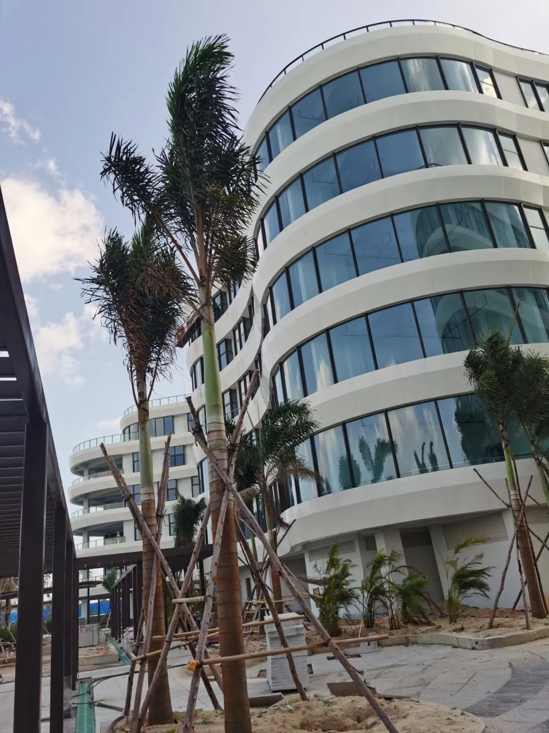 Exterior view of curved white solid aluminum facade bands around glazed window openings