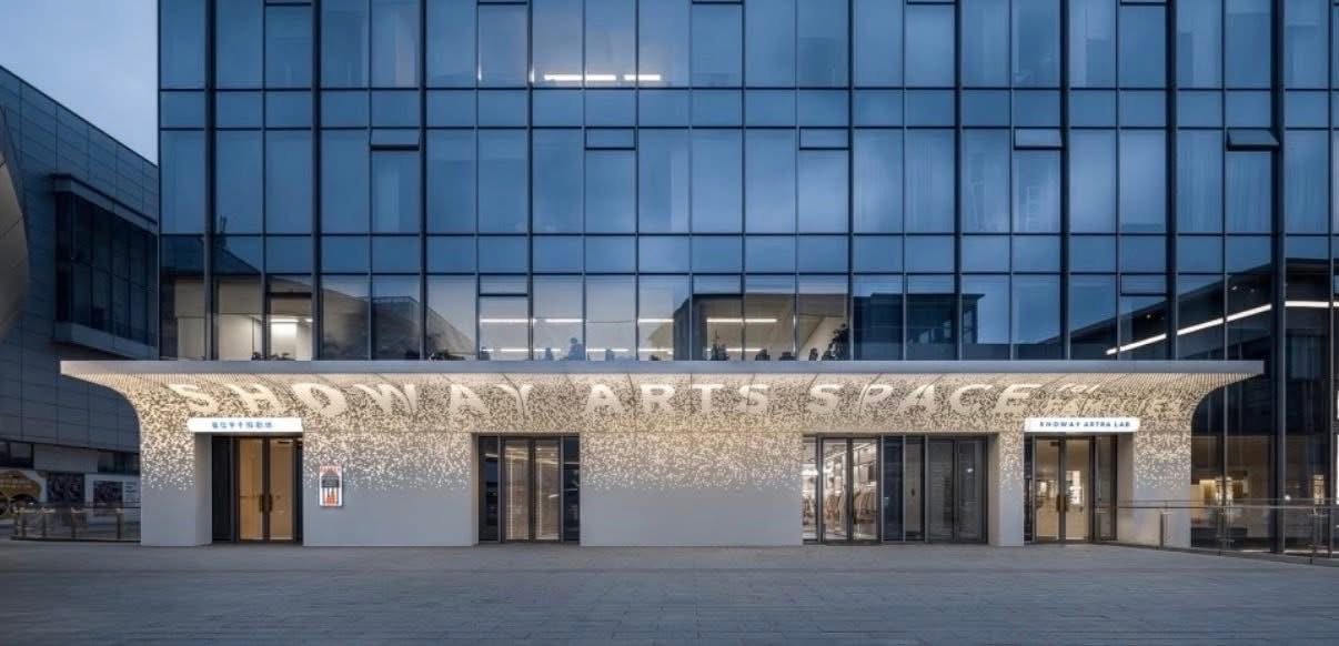 Commercial entrance facade with artistic perforated aluminum panels and backlit dot pattern by Punchuk