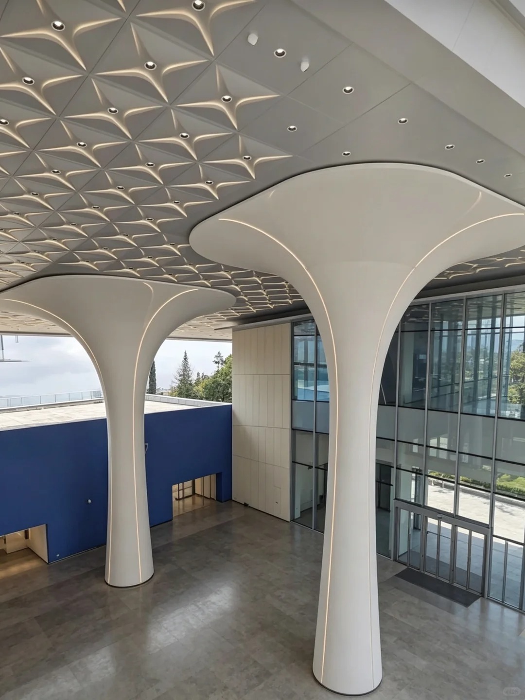 Solid aluminum ceiling and column cladding with double curved transitions in a public interior