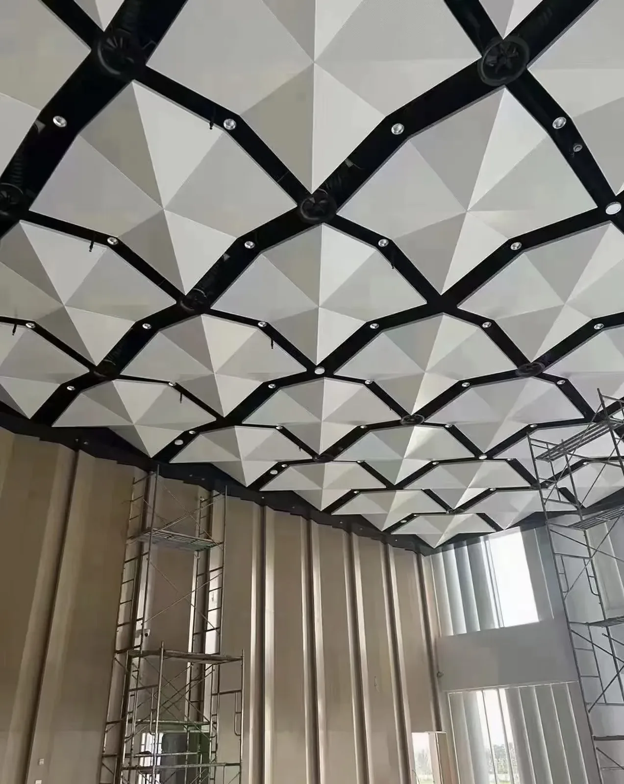 White faceted solid aluminum ceiling modules during installation